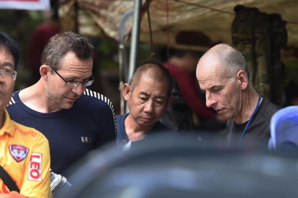 Two British divers John Volanthen (L) and Richard William Stanton (R) are seen with Thai rescue personnel at the Tham Luang cave area at Khun Nam Nang Non Forest Park in the Mae Sai district of Chiang Rai province on July 3, 2018 after finding the childre