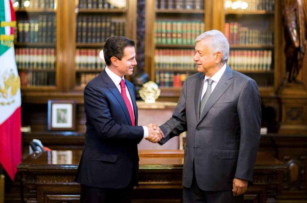 Mexico's President Enrique Pena Nieto and Mexico's president-elect Andres Manuel Lopez Obrador shake hands during a meeting at National Palace in Mexico City, Mexico in this handout photograph released to Reuters by the Mexico Presidency, July 3, 2018. Me
