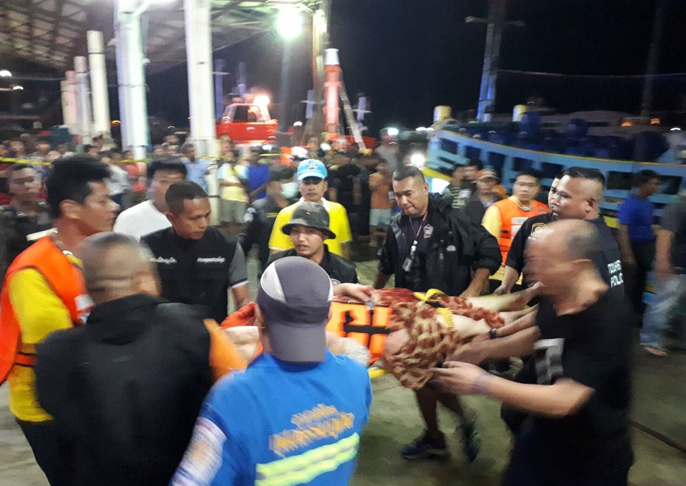 Thai rescue and paramedic personnel attend to rescued passengers of capsized tourist boat in rough seas at a port in Phuket on July 5, 2018. AFP / Kritsada Muenhawong