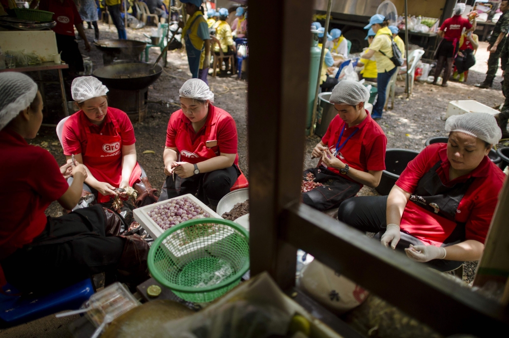 Thai volunteers prepare food in a mobile canteen at the Tham Luang cave area as rescue operations continue for 12 boys and their coach trapped at the cave at Khun Nam Nang Non Forest Park in the Mae Sai district of Chiang Rai province on July 5, 2018.  AF