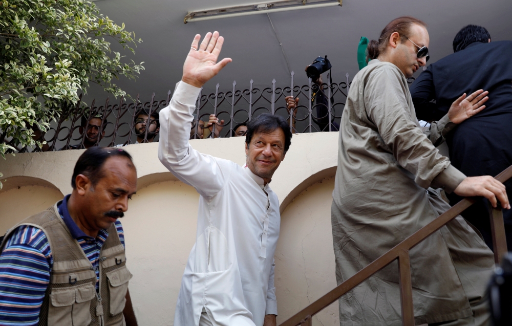 Imran Khan, chairman of the Pakistan Tehreek-e-Insaf (PTI), waves to supporters as he arrives to meet Zafar Ali Shah of Pakistan Muslim League-Nawaz (PML-N), who recently joined PTI party, in Islamabad, Pakistan July 5, 2018. (REUTERS/Faisal Mahmood)