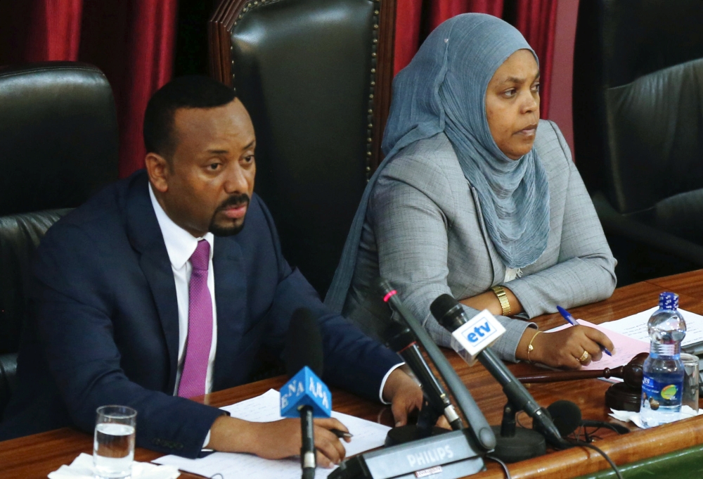 Ethiopia's newly elected Prime Minister Abiy Ahmed (L), flanked by parliament speaker, Muferiat Kamil, addresses the members of parliament inside the House of Peoples' Representatives, during a meeting for the approval of 2018/19 budget in Addis Ababa, Et