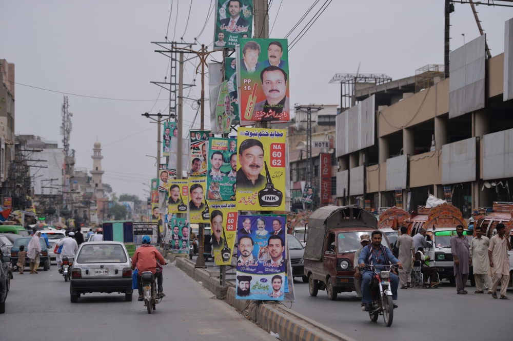 (FILES) In this file photo taken on June 28, 2018 Pakistani motorists drive along a road with posters of candidates taking part in the forthcoming general elections, in the garrison city of Rawalpindi. AFP / Aamir Qureshi 
