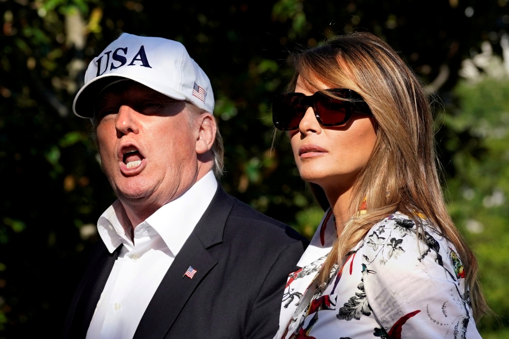 U.S. President Donald Trump talks to reporters as he walks with first lady Melania Trump on the South Lawn of the White House upon their return from Bedminster, New Jersey, to Washington, U.S., July 8, 2018. REUTERS/Yuri Gripas 