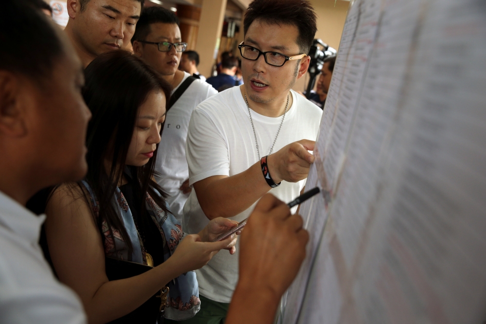 Relatives of Chinese tourists involved in a sunken tourist boat accident, search for their relative's name on a list at a hospital in Phuket, Thailand, July 7, 2018. REUTERS/Athit Perawongmetha
