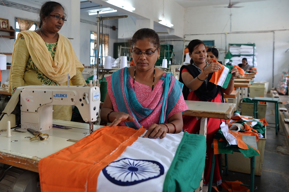 This photo taken on May 9, 2018 shows employees of Khadi Gramodyog Samyukta Sangh stitching together an Indian national flag at the Indian National Flag Production Centre in Bengeri in the southern state of Karnataka. AFP / Manjunath Kiran  