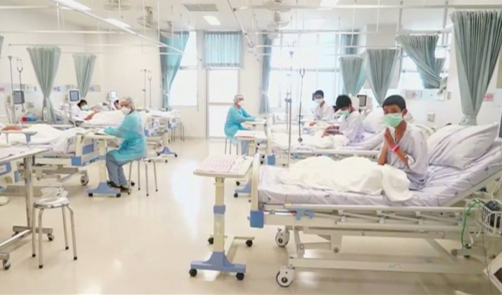 Boys rescued from the Thai cave wear masks and rest at a hospital in Chiang Rai, Thailand in this still image taken from a July 11, 2018 handout video. Government Public Relations Department (PRD) and Government Spokesman Bureau/Handout via REUTERS TV