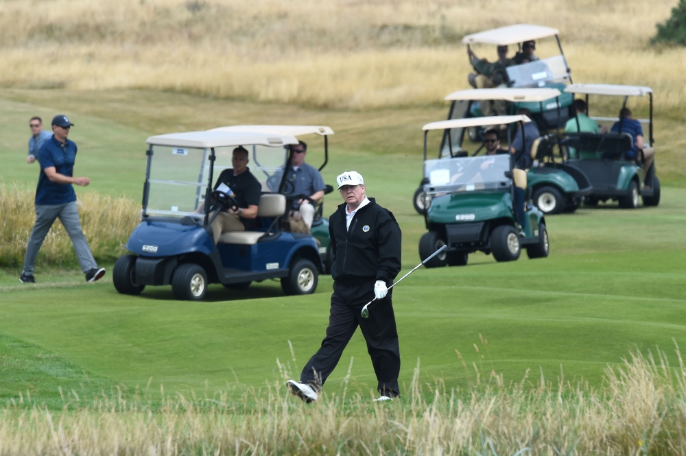 US President Donald Trump (C) walks as he plays a round of golf on the Ailsa course at Trump Turnberry, the luxury golf resort of US President Donald Trump, in Turnberry, southwest of Glasgow, Scotland on July 14, 2018, during the private part of his four