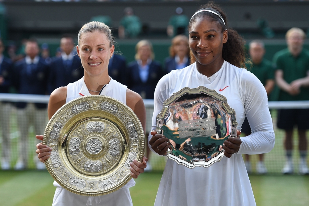 Germany's Angelique Kerber (L) holds the winner's trophy, the Venus Rosewater Dish, after her women's singles final victory over US player Serena Williams on the twelfth day of the 2018 Wimbledon Championships at The All England Lawn Tennis Club in Wimble