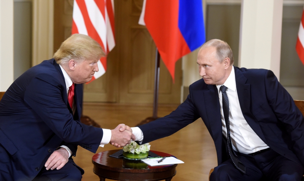 U.S. President Donald Trump shakes hands with Russia's President Vladimir Putin during a meeting in Helsinki, Finland July 16, 2018. Lehtikuva/Heikki Saukkomaa via REUTERS