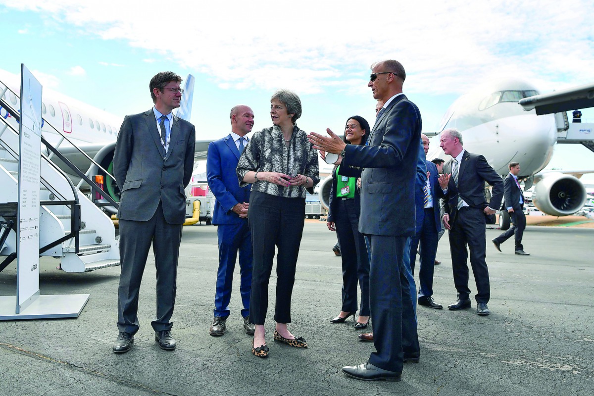 Britain's Prime Minister Theresa May (C) is accompanied by Airbus CEO Tom Enders (R) on her arrival at the Farnborough Airshow, south west of London, on July 16, 2018. AFP / Ben Stansall