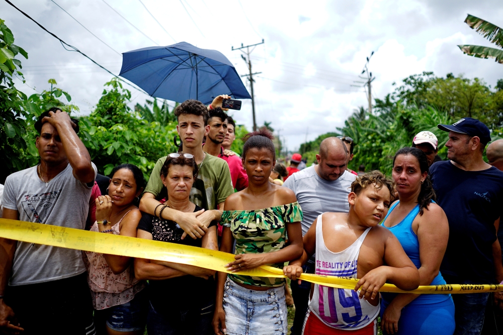 People look on near of the wreckage of a Boeing 737 plane that crashed in the agricultural area in Boyeros, around 20 km south of Havana, May 18, 2018 (Reuters / Alexandre Meneghini) 