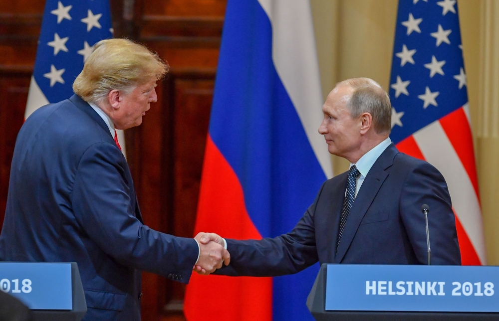 Donald Trump and Vladimir Putin shake hands before attending a joint press conference after a meeting at the Presidential Palace in Helsinki on July 16, 2018. (AFP / Yuri Kadobnov) 