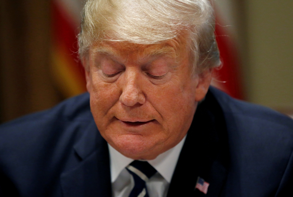 U.S. President Donald Trump reads from prepared remarks as he speaks about his summit meeting with Russia's President Vladimir Putin at the start of a meeting with members of the U.S. Congress at the White House in Washington, July 17, 2018. REUTERS/Leah 
