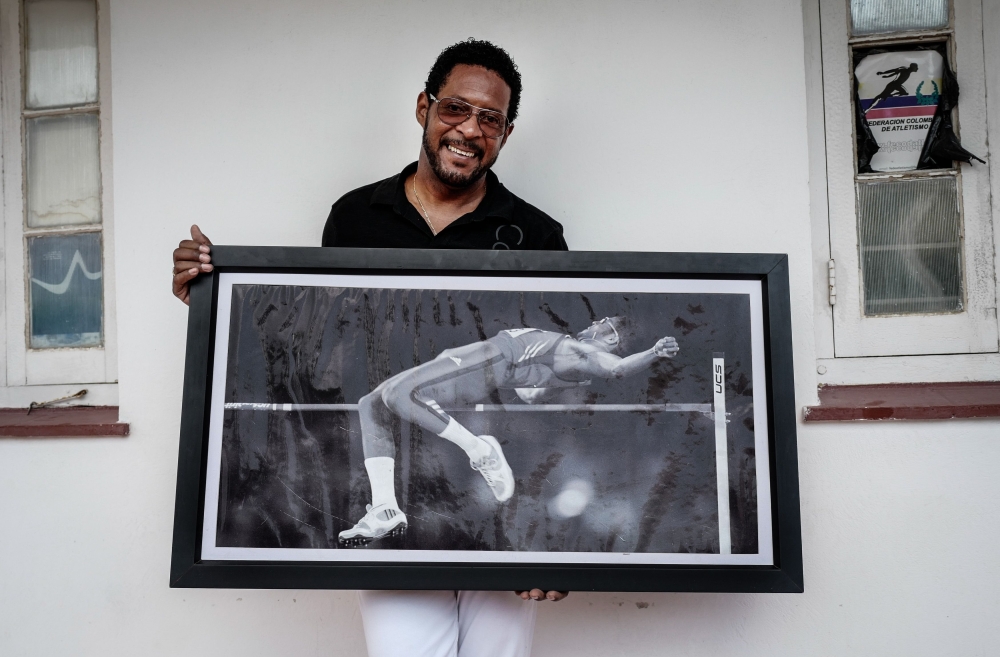 Cuban former high jumper Javier Sotomayor poses with a picture of himself in Havana, on June 20, 2018. (AFP / ADALBERTO ROQUE)