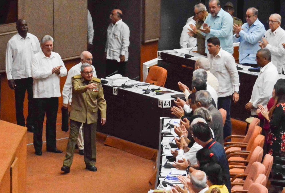 Cuba's President Miguel Diaz-Canel (2-L) applauds as former President Raul Castro (4-L) waves upon arriving to attend the National Assembly's session to present the new Council of Ministers and discuss the draft of 224 articles prepared by a parliamentary