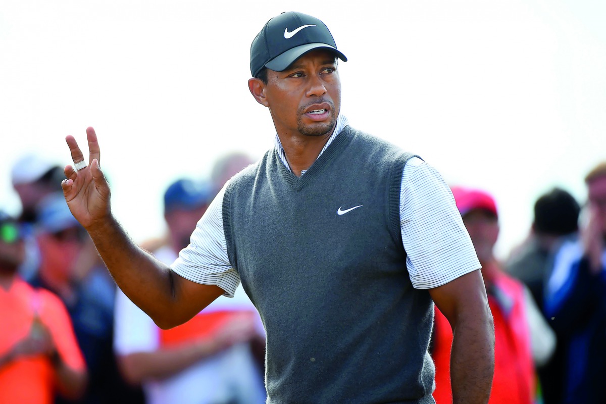 US golfer Tiger Woods acknowledges the applause after playing his shot from the 16th tee during his third round on day 3 of The 147th Open golf Championship at Carnoustie, Scotland on July 21, 2018. AFP / Andy Buchanan