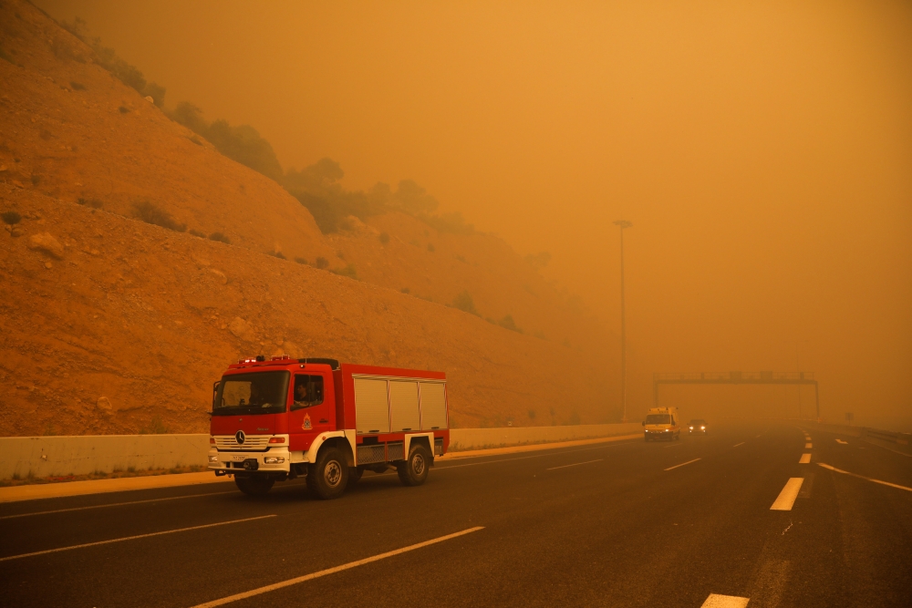 Fire fighters are seen amid smoke as a wildfire burns in Kineta, near Athens, Greece, July 23, 2018. Reuters/Alkis Konstantinidis

