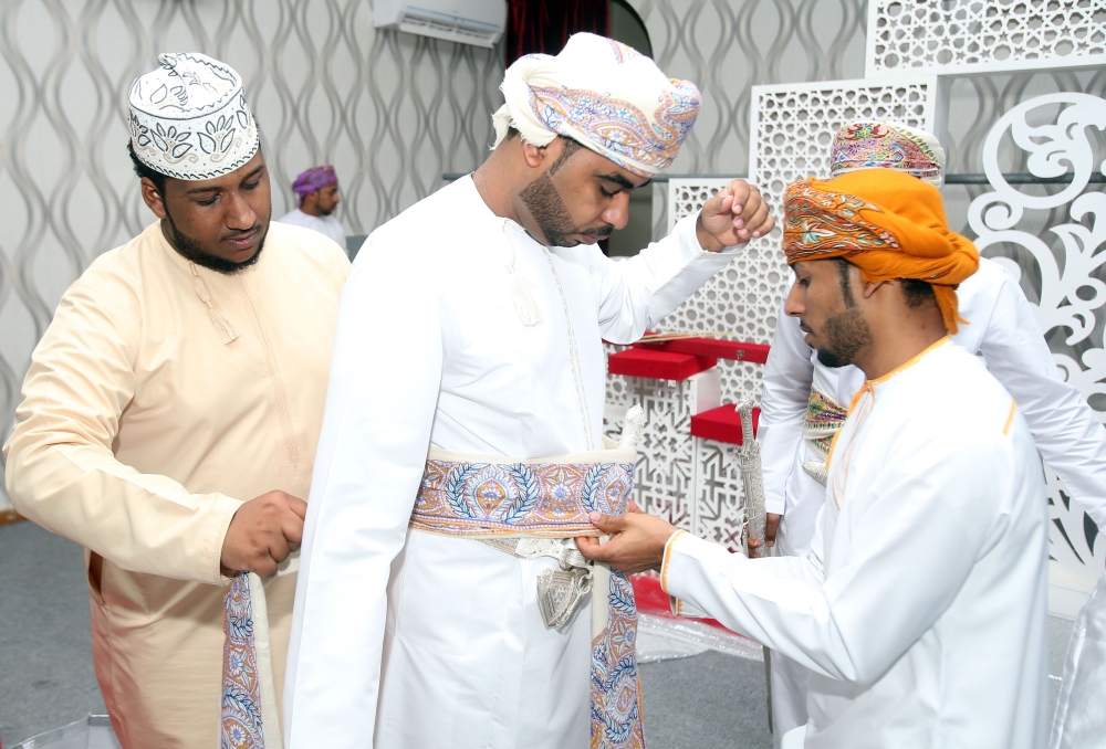 Omani grooms dress up ahead of a mass wedding ceremony of 24 couples in Al-Mudhaibi province on July 20, 2018. AFP / Mohammed Mahjoub