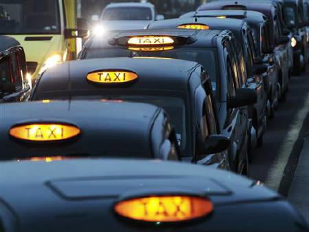 Black taxi cabs queue at a taxi rank near Paddington Station, in London. REUTERS/Luke MacGregor/File photo
