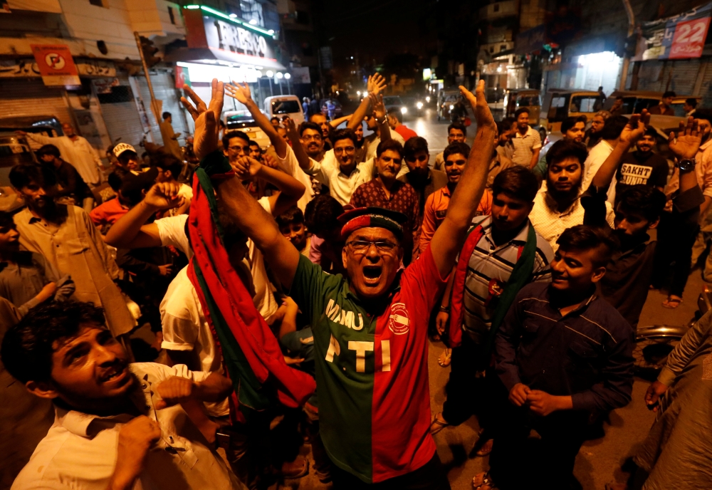 Supporters of Pakistan Tehreek-e-Insaf (PTI) political party celebrate along the road during the general election in Karachi, Pakistan July 25, 2018. REUTERS/Akhtar Soomro