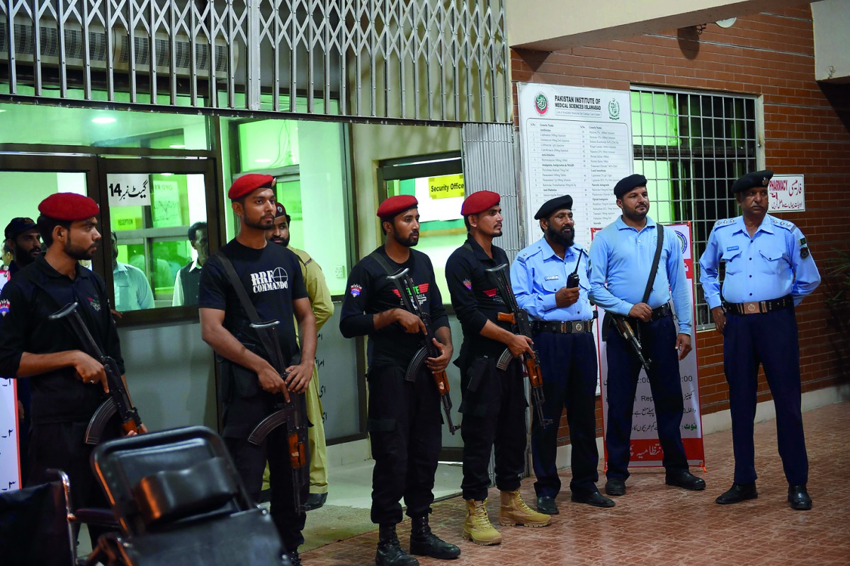 Pakistani police commandos and policemen stand guard at the entrance of the cardiac centre at the Pakistan Institute of Medical Sciences in Islamabad.  AFP / Farooq Naeem