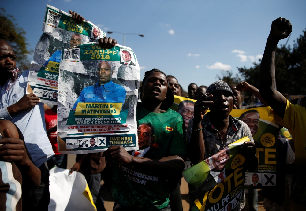 Supporters of the ruling ZANU-PF party of President Emmerson Mnangagwa celebrate following general elections in Harare, Zimbabwe, July 31, 2018. (REUTERS/Philimon Bulawayo)