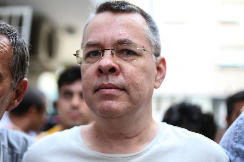 In this file photo taken on July 25, 2018 US pastor Andrew Craig Brunson is escorted by Turkish plainclothes police officers to his house on in Izmir.  AFP 