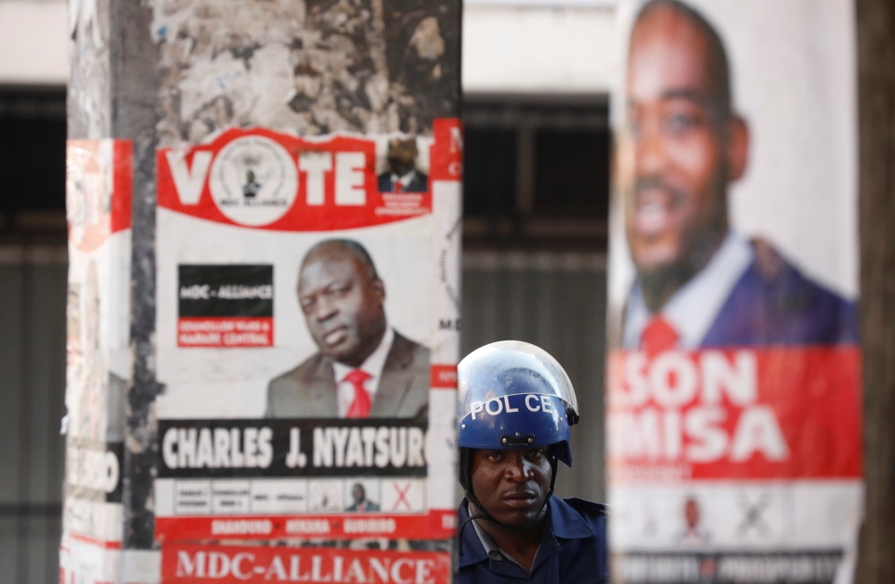 Police stand guard during a raid on the headquarters of the opposition Movement for Democratic Change (MDC) a day after post-election clashes between security forces and opposition protesters in Harare, Zimbabwe, August 2, 2018. Reuters/Mike Hutchings