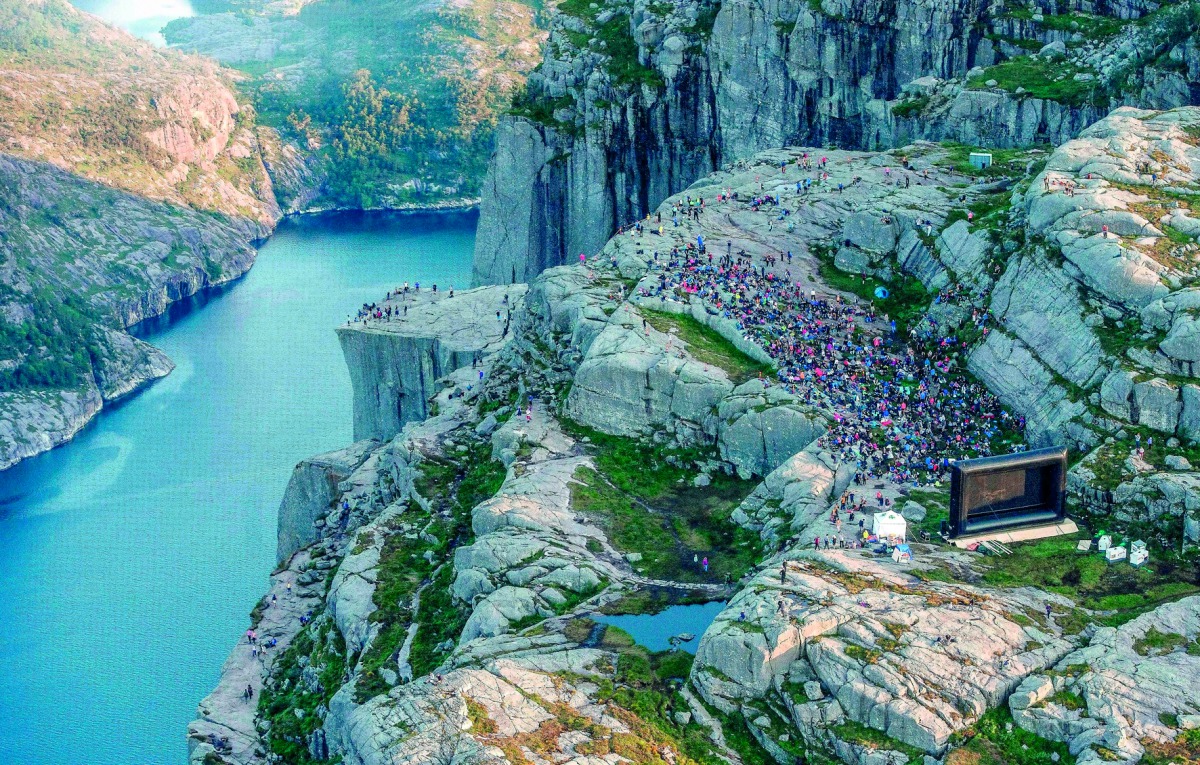 People gather in the mountains near Preikestolen (The Pullpit Rock) in Forsand near Stavanger, western Norway, on August 1, 2018, to see the movie 