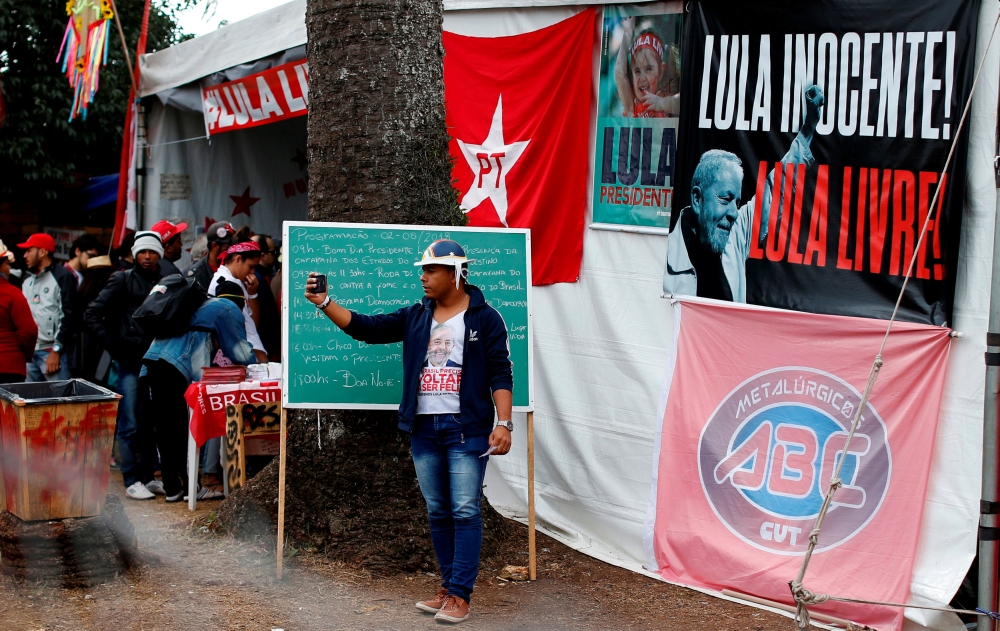 A supporter of former Brazilian President Luiz Inacio Lula da Silva takes a selfie in a camp near the Federal Police in Curitiba, Brazil August 2, 2018. The banner reads: