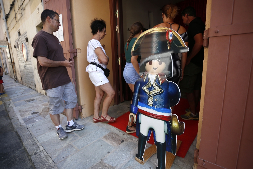 In this file photo taken on July 25, 2018 a woman with kids enters the Naporama museum, deficting Napoleon Bonaparte's life with playmobils in Ajaccio on the French Mediterranean island of Corsica. AFP / Pascal Pochard-Casabianca
 