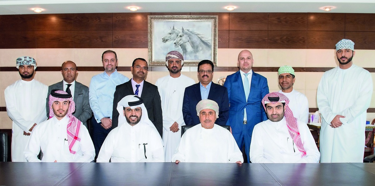 Abdul Aziz bin Nasser Al Khalifa (sitting, second left), Chairman, ELAN Group; Jaber Abdullah Al Ansari (sitting, right), CEO, ELAN Group; and Sheikh Mahmood Al Jarwani (sitting, second right), Chairman of TAMANI Global Development & Investment with other