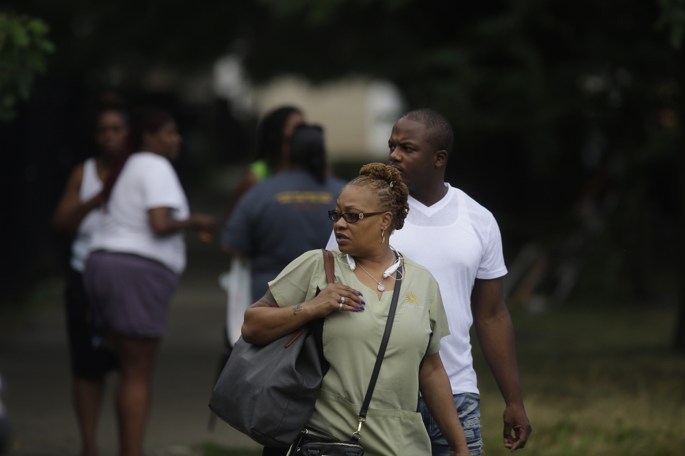 Bystanders watch as Chicago Police officers and detectives investigate a shooting where multiple people were shot on Sunday, August 5, 2018 in Chicago, Illinois. Joshua Lott/Getty Images/AFP