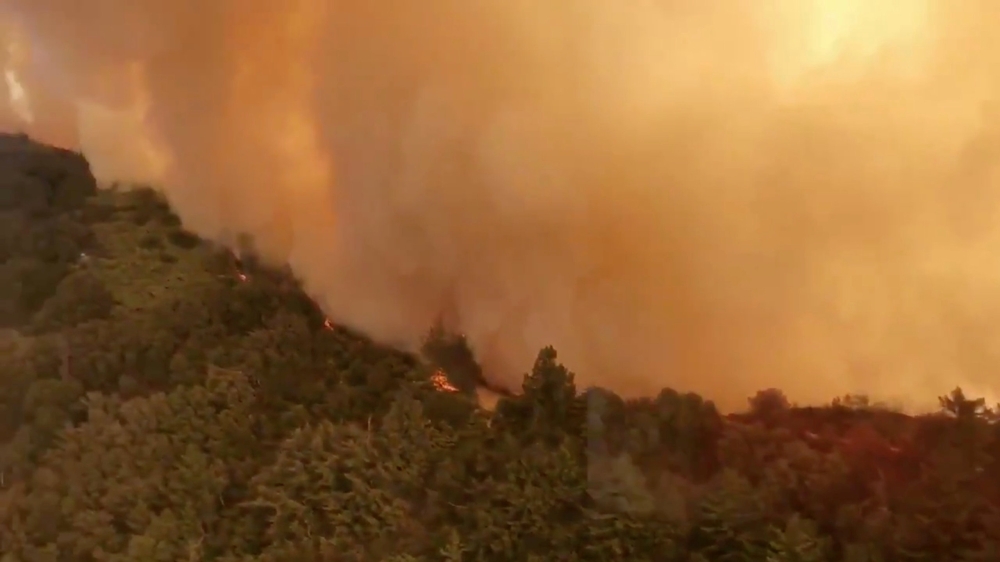 Aerial view of Trabuco Canyon as a tanker aircraft dumps load onto Holy Fire, Near Santiago Peak, California, US, August 6, 2018 in this still image taken from a video obtained from social media. TWITTER / @ZULUJUMPER/via REUTERS