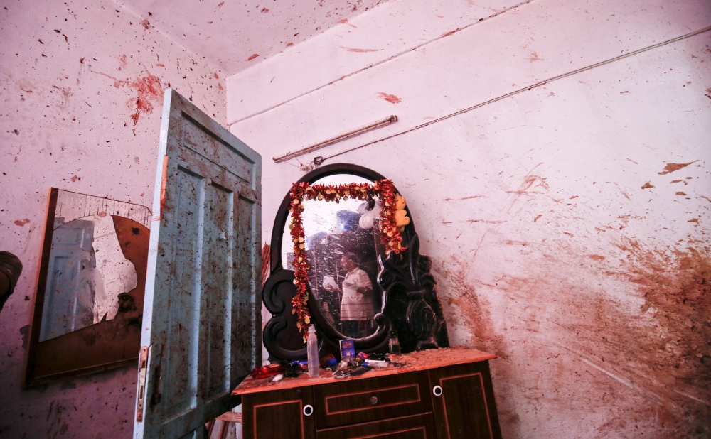 A relative of 23-year-old Palestinian Enas Khammash, who was killed with her toddler in an Israeli airstrike, inspects their bedroom in Deir Al-Balah in the central Gaza Strip on August 9, 2018. AFP / Said Khatib 