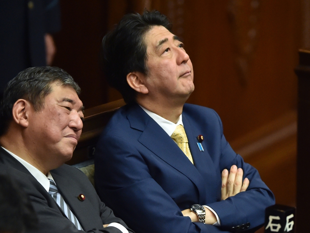 In this file photo taken on July 16, 2015 Japan's Prime Minister Shinzo Abe (R) and then Regional Revitalization Minister Shigeru Ishiba (L) listen to a speech by a member of an opposition party at the parliament in Tokyo. / AFP / Kazuhiro NOGI 