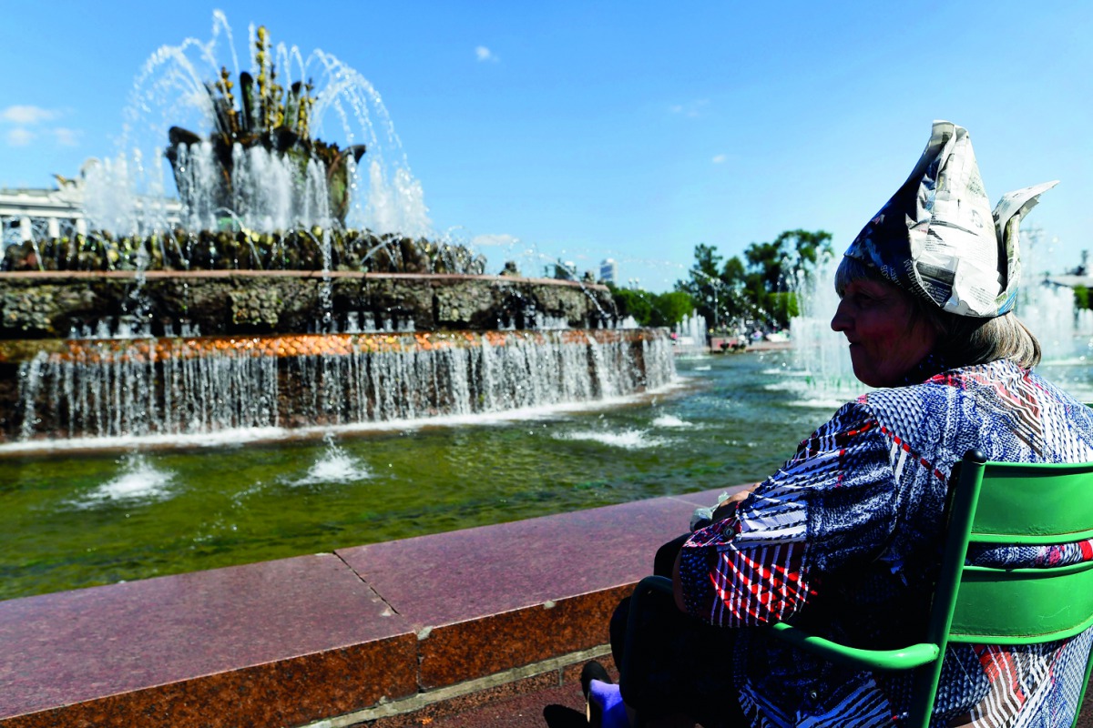 An elderly woman rests by a fountain in the All-Russia Exhibition Centre (VDNKh), a trade show and amusement park, with temperatures at around 28 degrees Celcius in Moscow on August 10, 2018. AFP / Kirill Kudryavtsev 