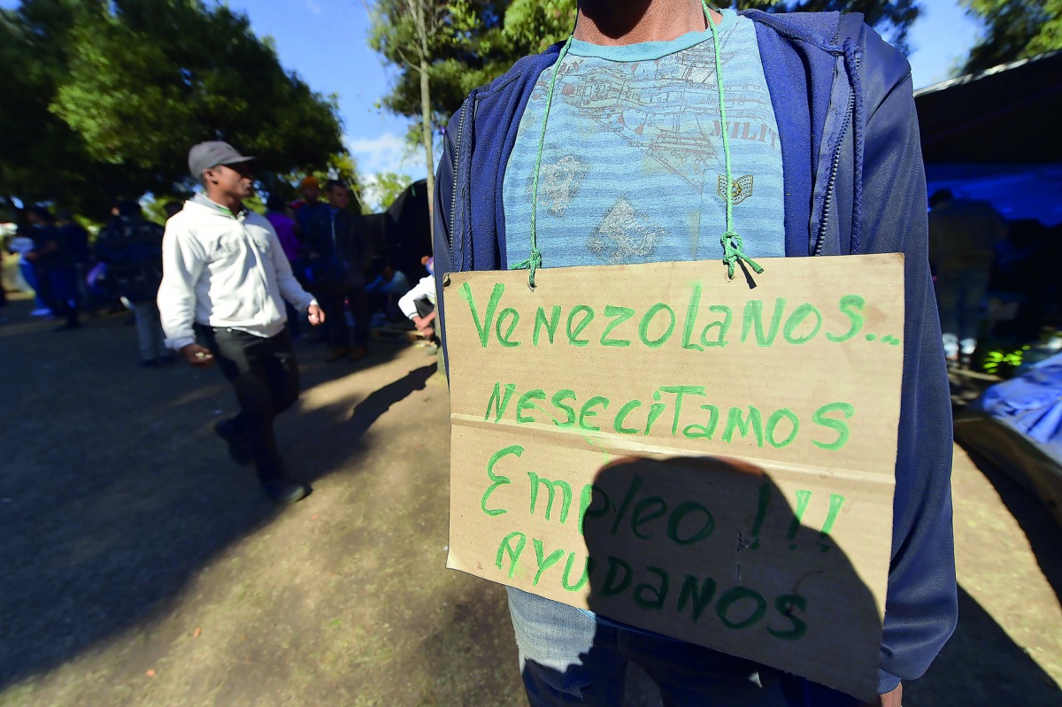 A man with a sign hanging that reads 