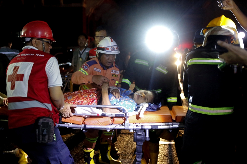 Rescuers carry a patient on a stretcher after a fire broke out at Yangon General Hospital, in Yangon, Myanmar, August 13, 2018. Reuters/Ann Wang