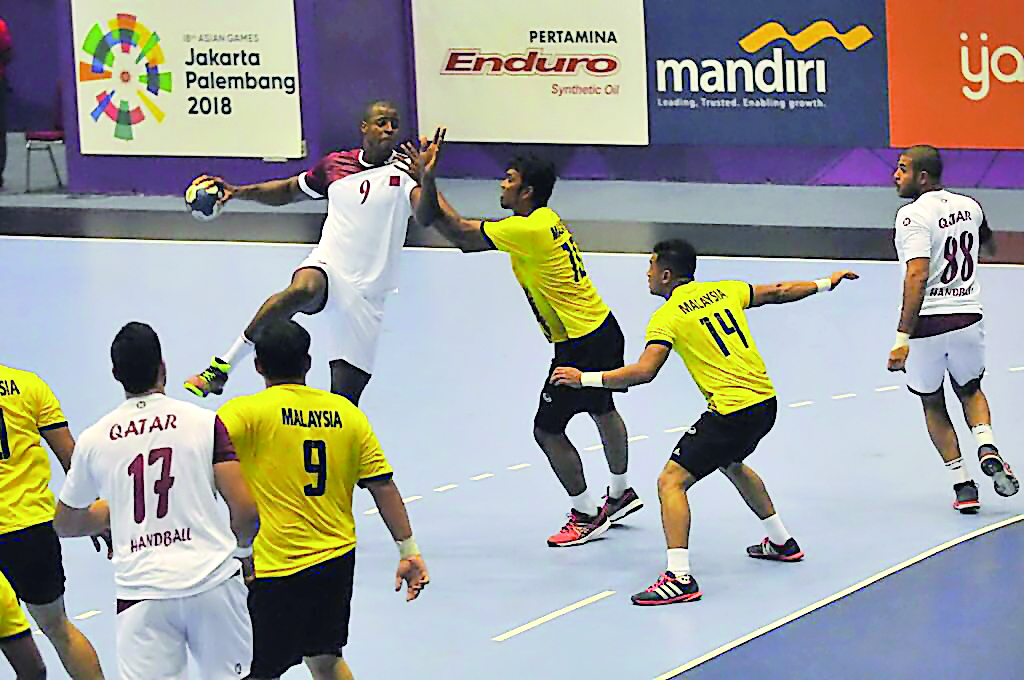 A Qatari player shoots the ball during match against Malaysia. 