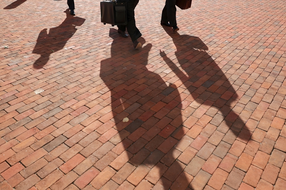 Attorneys for former Trump campaign chairman Paul Manafort, cast long shadows as they arrive at the Albert V. Bryan U.S. Courthouse for the eleventh day of Manafort's trial August 14, 2018 in Alexandria, Virginia. Chip Somodevilla/Getty Images/AFP 