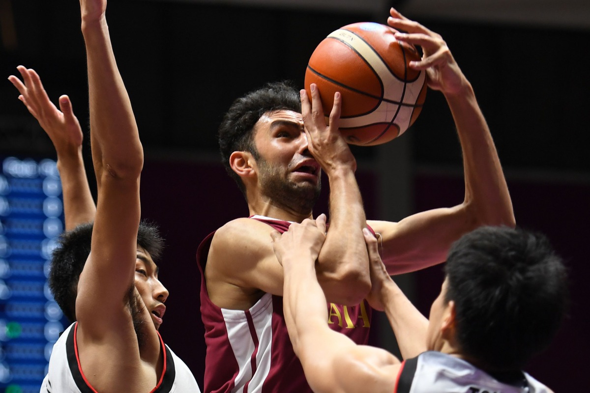 Qatar’s Khaled Abdelbaset (centre) is blocked by Japan’s Shogo Tamaki (left) and Naoto Tsuji during their Group C preliminary round match of the 2018 Asian Games in Jakarta, Indonesia, yesterday.