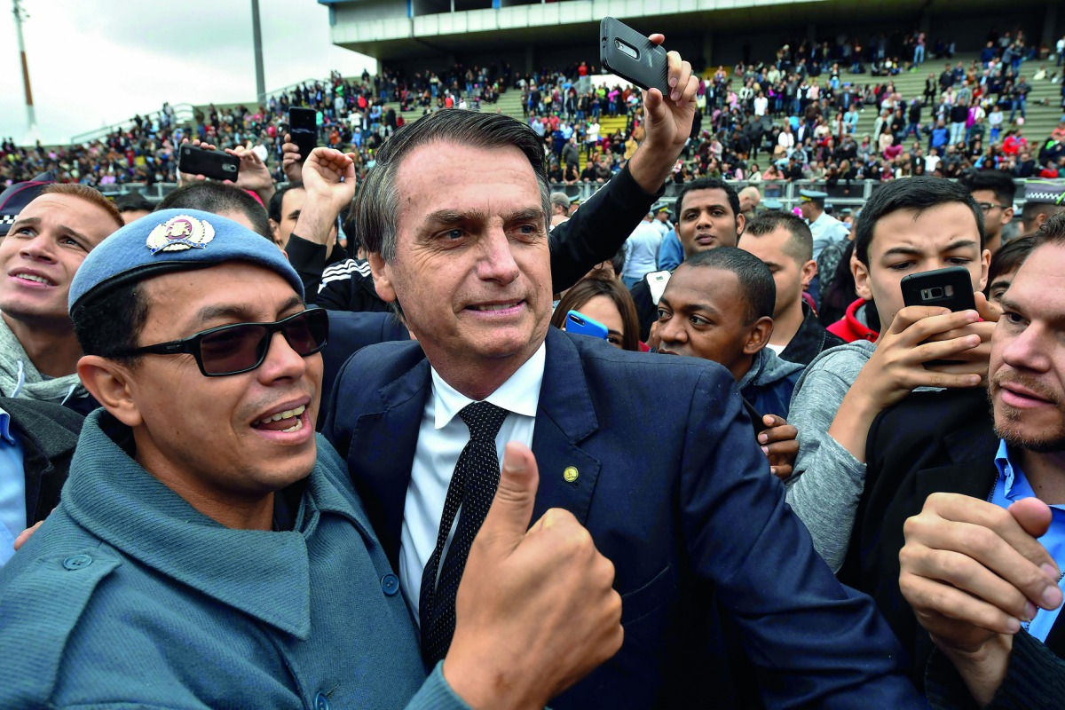 Brazilian presidential candidate for the Social Liberal Party (PSL) Jair Bolsonaro (C) poses for a picture with a military woman during the graduation ceremony of a military school in Sao Paulo, Brazil on August 17, 2018. Brazilian general elections will 