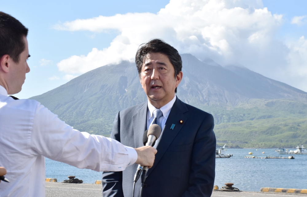 Japan's Prime Minister Shinzo Abe speaks to the media as he announces his candidacy for the upcoming ruling Liberal Democratic Party presidential election, during a press conference in front of Mount Sakurajima volcano while on tour to Tarumizu, Kagoshima