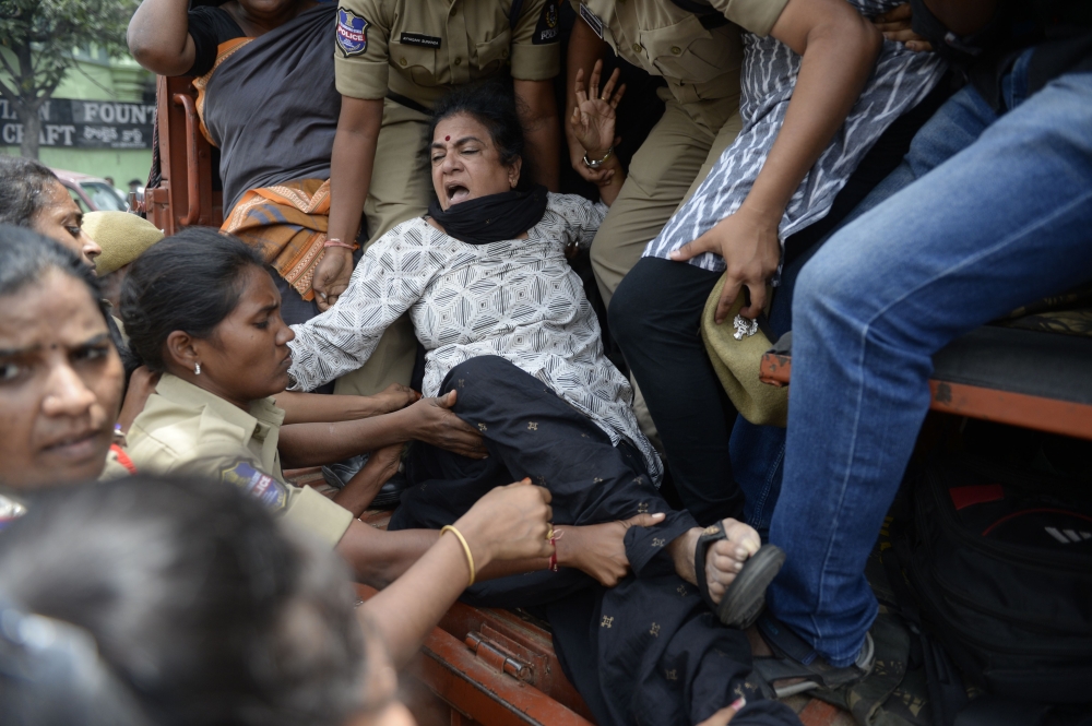 Police detains Progressive Organisation for Women (POW) leader Sandhya (C) during a protest against the arrest of poet and activist Varavara Rao in Hyderabad, on August 29, 2018.  AFP / Noah Seelam 