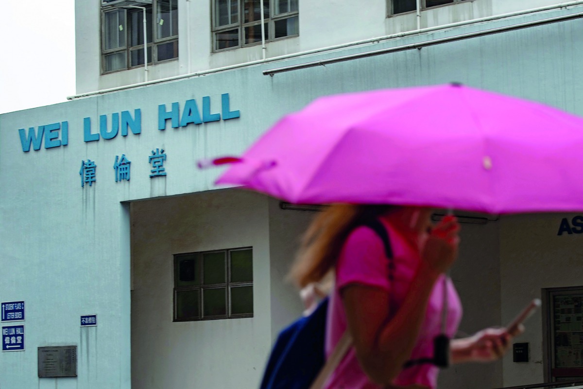 A student walks in front of University of Hong Kong's Wei Lun Hall, the residential block where university professor Cheung Kie-chung and his family lived, in Ho1ng Kong's Pok Fu Lam area on August 29, 2018.  AFP / Philip Fong 