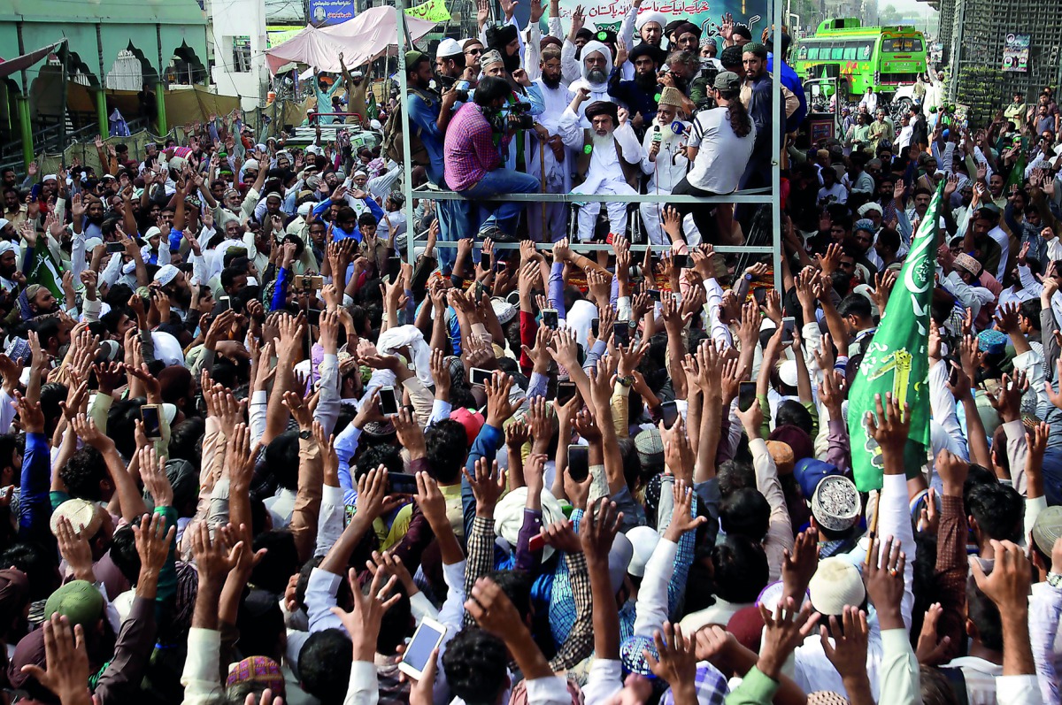 Supporters of the Tehrik-e-Labaik Pakistan (TLP) Islamist political party raise their hands as they listen to the speech of their leader during a protest march to condemn the cartoon competition by the Netherlands, in Lahore, Pakistan August 29, 2018. Reu