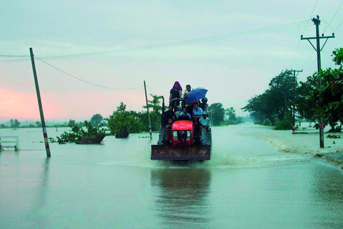 Flood victims ride a farm vehicle in Yedashe township, Bago region after rampaging flood waters from Swar Chaung dam submerged large areas in central Myanmar on August 29, 2018.  AFP / Ye Aung Thu
 