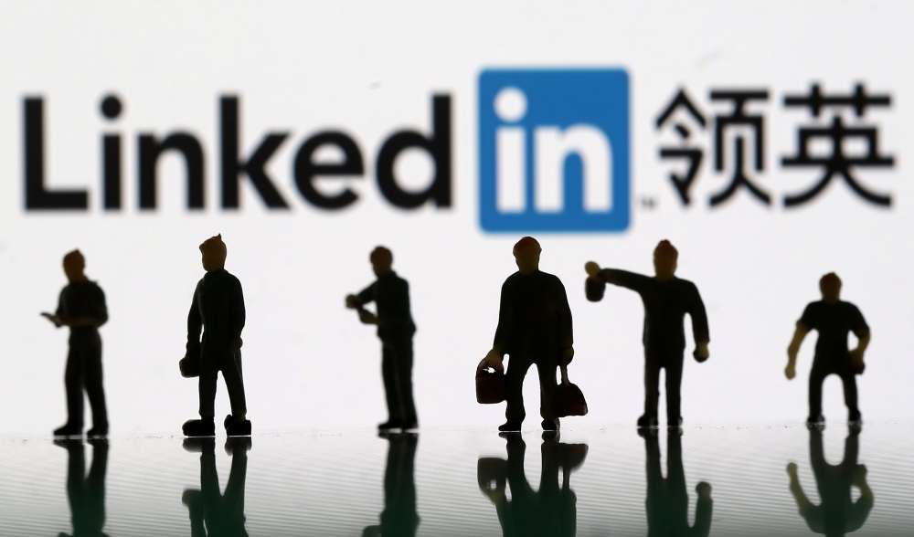 Small toy figures are seen in the backdrop of Linkedin logo in this illustration picture, August 30, 2018. Reuters/Dado Ruvic